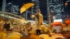 FILE - A protester holds an umbrella during a performance on a main road in the occupied areas outside government headquarters in Hong Kong's Admiralty in Hong Kong, Oct. 9, 2014. 
