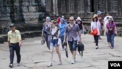 A tour guide leads a group of tourists in Siem Reap's Angkor Wat Temple on Saturday, July 16, 2016. (Photo: Leng Len/VOA Khmer)