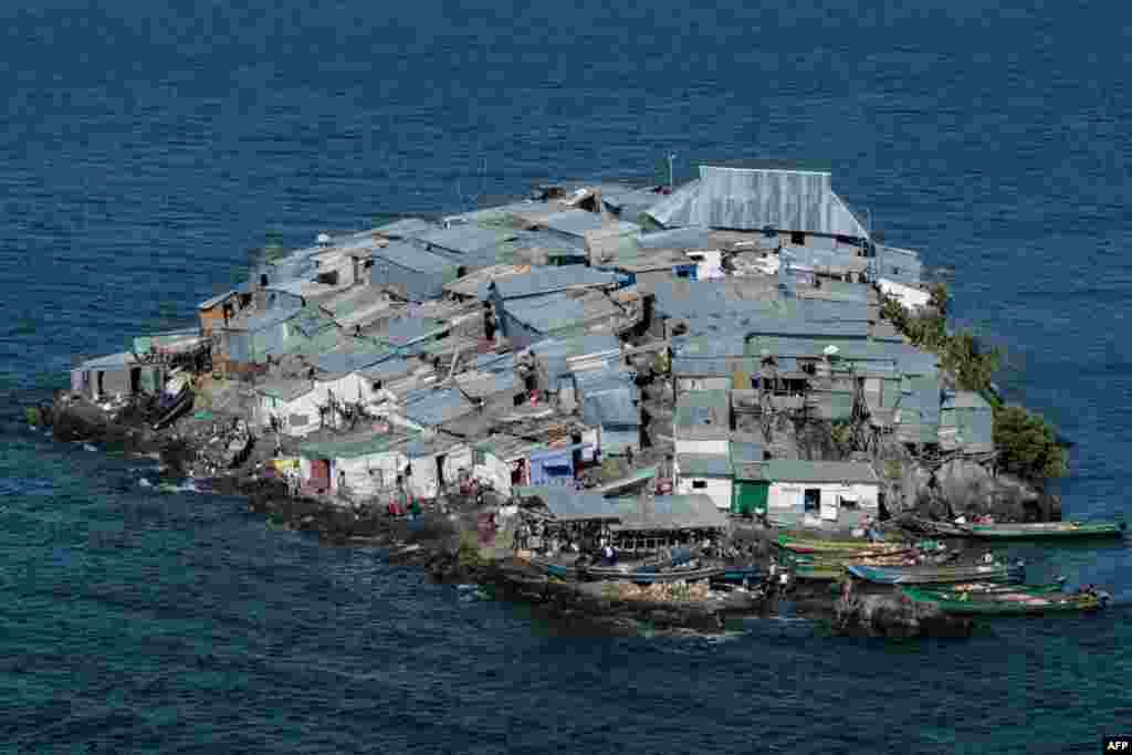 A rocky outcrop covered in metallic shacks, Migingo Island rises out of the waters of Lake Victoria on the border of Uganda and Kenya. The densely-populated island is barely a quarter of a hectare large, its residents crammed into a hodgepodge of corrugated-iron homes, bars, brothels and a tiny port.