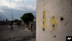 Bullet holes mark a wall at an intersection where a video released by Mexican media outlets appeared to show a soldier executing a civilian lying face down in the street with a shot to the back of his head, in Palmarito Tochapan, Puebla State, May 10, 2017.