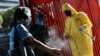 Un agent de la santé pulvérise du désinfectant sur une dame à Caracas, Venezuela, 18 mars 2020. (Photo: Reuters)