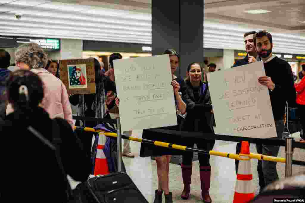 Des avocats accueillent les touristes et les résidents à l'aéroport international de Washington DC, le 31 janvier 2017. (VOA/Nastasia Peteuil)