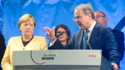 Gubernur Armin Laschet, pemimpin partai CDU, berbicara kepada pendukungnya didampingi Angela Merkel (kiri).