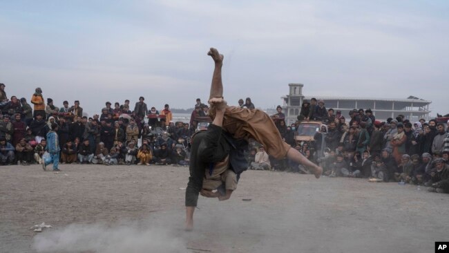 Afghan men wrestle in Kabul, Dec. 3 , 2021. The scene is one played out weekly after Friday prayers in Chaman-e-Huzori park in downtown Kabul, where men, mainly from Afghanistan's northern provinces, gather to watch and to compete in pahlawani, a traditional form of wrestling.