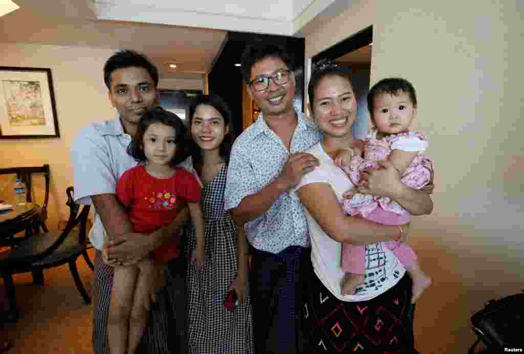 Reuters reporter Wa Lone poses with wife Pan Ei Mon and daughter, along with Reuters reporter Kyaw Soe Oo carrying his daughter next to wife Chit Su Win, after being freed from prison, after receiving a presidential pardon in Yangon, Myanmar, May 7, 2019.