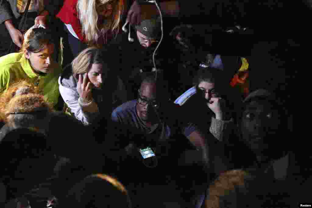 People listen to a radio as South African President Jacob Zuma announces the death of former South African President Nelson Mandela in Houghton, Dec. 5, 2013. 