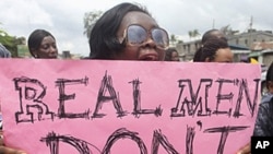 A woman carries a placard as she shouts a slogan during the "walk against rape'" procession organized by "Project Alert", a Lagos-based NGO focusing on women's issues, in Nigeria's commercial capital Lagos.