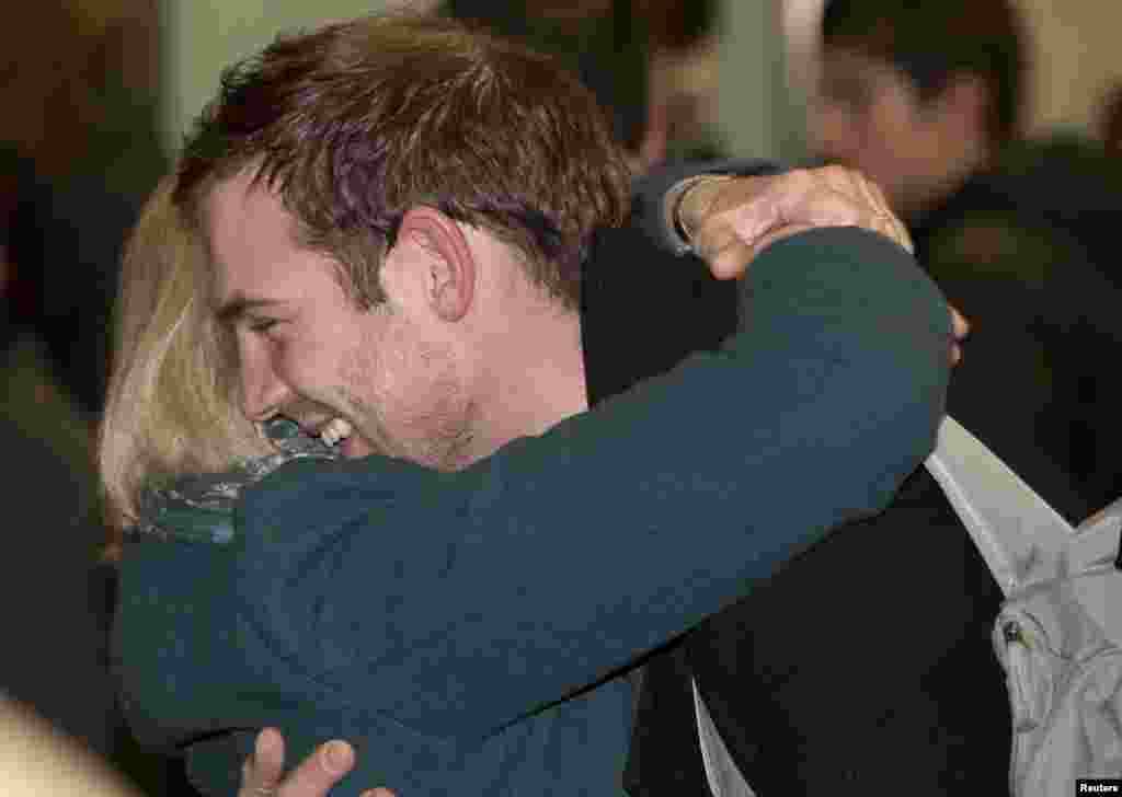 Video cameraman Kieron Bryan hugs his mother Ann after arriving at St. Pancras station in central London, England, Dec. 27, 2013. 