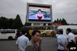 People watch a news broadcast announcing the Singapore summit meeting between North Korean leader Kim Jong Un and U.S. President Donald Trump, on a giant television screen outside the central railway station in Pyongyang, June 13, 2018.