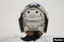 FILE - South Korean women's ice hockey goaltender So Jung Shin has the Olympic rings painted on her helmet, ahead of the South Korea Winter Olympics, during practice in Hamden, Conn., Dec. 27, 2017.
