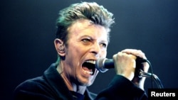 FILE - British Pop Star David Bowie screams into the microphone as he performs on stage during his concert in Vienna, Feb. 4, 1996.