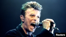 FILE - British Pop Star David Bowie screams into the microphone as he performs on stage during his concert in Vienna, Feb. 4, 1996.