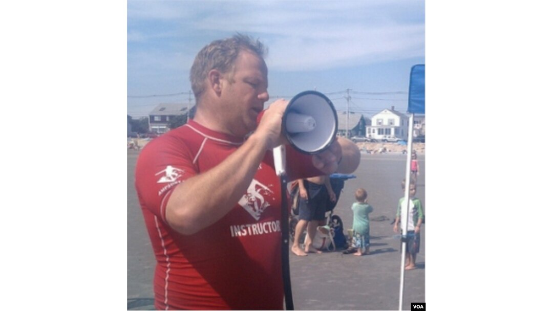 Pendiri AmpSurf Dana Cummings memberi aba-aba dengan megaphone ketika ia menyambut para peserta kelas berselancar di Maine.