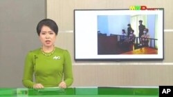 In this image from Myawaddy TV, a photograph of deposed Myanmar leader Aung San Suu Kyi's court appearance was shown during a report about her case is read by a news presenter Monday, May 24, 2021, in Naypyitaw, Myanmar. (Myawaddy TV via AP)