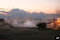 In this photo taken on Oct. 7, 2015, Syrian army howitzers fire near the village of Morek in Syria.