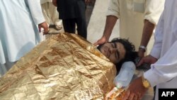 Pakistani men carry an injured bombing victim into a hospital in Kohat following an attack on the home of Maulvi Nabi Hanfi, Oct. 3, 2013.