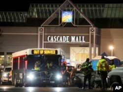 Emergency personnel stand in front of an entrance to the Cascade Mall at the scene of a shooting where several people were killed, Sept. 23, 2016, in Burlington, Washington.