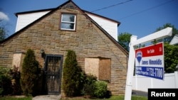 FILE - A 'for sale' is seen outside a single family house in Garden City, New York, US.