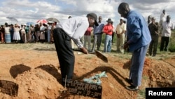 FILE: Relatives cover the grave of cholera victim Betty Mubata during her burial at Chitungwiza Unit L cemetery, 27km (17 miles ) south of the capital Harare, December 8, 2008. REUTERS/Philimon Bulawayo (ZIMBABWE) - RTR22E3J