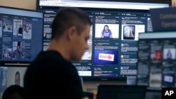 FILE - A man works in the war room, where Facebook monitors election-related content, in Menlo Park, Calif., Oct. 17, 2018.