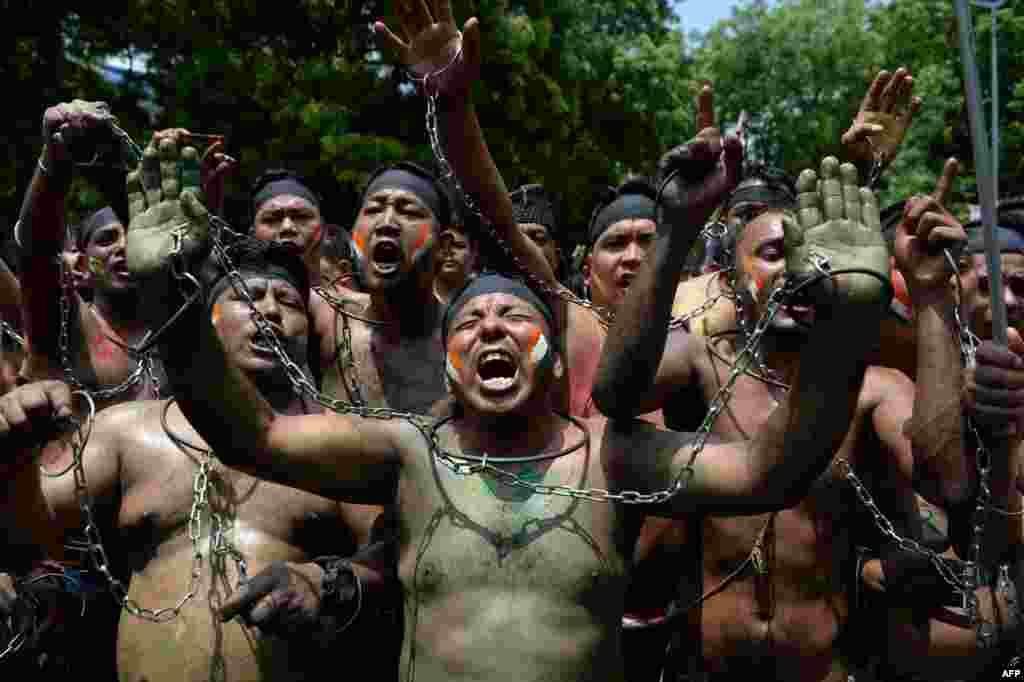 Indian supporters of Gorkhaland chant slogans tied with chains during a protest march in capital New Delhi.