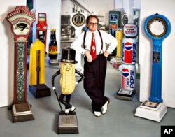 In his artist's studio, Christopher Steele strikes a rakish pose among his collection of vintage penny scales – some dispense fortunes and trinkets