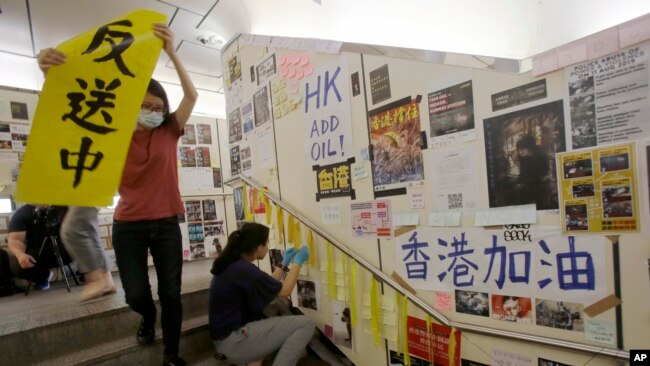在台湾的香港学生为执行当地政府的指令从一面连侬墙上移走标语。（2019年8月31日）