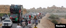The convoy of Bilawal Bhutto Zardari, chairman of the Pakistan People's Party, passes the Makkli necropolis, during a campaign rally ahead of general elections in District Thatta, Pakistan, July 2, 2018.