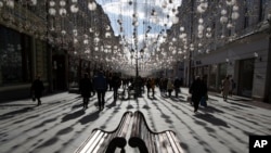 FILE - People walk along Nikolskaya Street near the Kremlin on a sunny day in Moscow, Russia, March 9, 2019. 