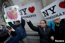 FILE - Demonstrators hold pro-immigration signs during a protest against Republican U.S. presidential candidate Donald Trump in midtown Manhattan in New York City, April 14, 2016.