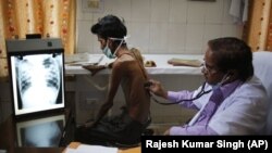 အန္ဒိယနိုင်ငံတွင် TB ရောဂါ လူနာရှင်ကို ဆရာဝန်က စမ်းသပ်နေစဉ် (မတ်လ ၂၄ ရက် ၂၀၁၄)