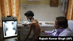  In this March 24, 2014, file photo, a doctor examines a tuberculosis patient in a government TB hospital in Allahabad, India. 