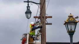 AT&T workers wear face masks during the coronavirus pandemic as they deploy fiber optic lines for a cell phone tower station in the Chinatown neighborhood of Los Angeles, Friday, June 5, 2020. (AP Photo/Damian Dovarganes)