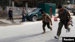 Afghan security forces run after a suicide car bomb attack in Jalalabad province, March 20, 2014.
