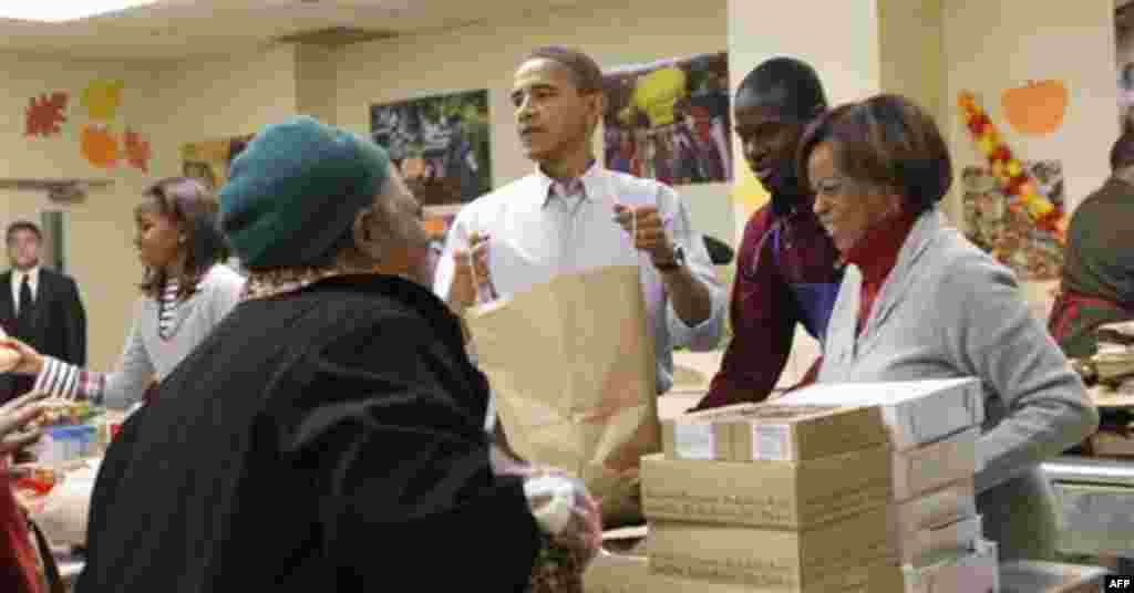 President Barack Obama, center, and members of his family, pack food for Thanksgiving at Martha's Table, a local food pantry in Washington, Wednesday, Nov. 24, 2010. Also with Obama are his daughter Sasha, left, and his mother-in-law Marian Robinson, righ