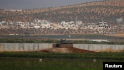 A Turkish military armoured vehicle guards on the border line located opposite the Syrian Atimah, Idlib province in Reyhanli, Hatay province, Turkey, Oct. 8, 2017.