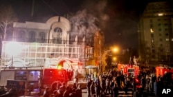 Smoke rises as Iranian protesters set fire to the Saudi embassy in Tehran, Jan. 3, 2016.