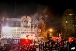 Smoke rises as Iranian protesters set fire to the Saudi Embassy in Tehran, Jan. 3, 2016.
