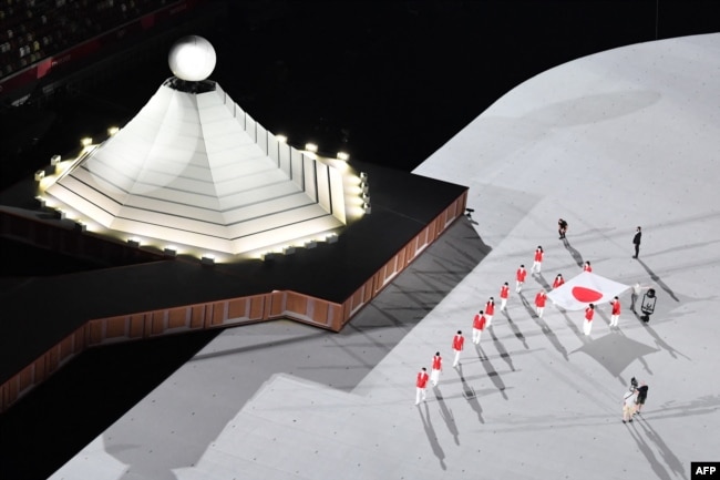 Bendera nasional Jepang dibawa ke lapangan dalam upacara pembukaan Olimpiade Tokyo 2020, di Stadion Olimpiade, di Tokyo, 23 Juli 2021. (AFP)