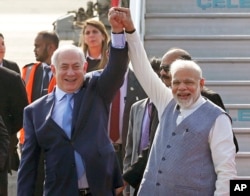 Israel's Prime Minister Benjamin Netanyahu, left, is welcomed by India's Prime Minister Narendra Modi on his arrival at Palam airport in New Delhi Sunday, Jan. 14, 2018.