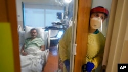 ARCHIVO - La enfermera Rachel Chamberlin sale de una sala de aislamiento donde Fred Rutherford se recupera de COVID-19 en el Centro Médico Dartmouth-Hitchcock, en Lebanon, EEUU, el 3 de enero de 2022.