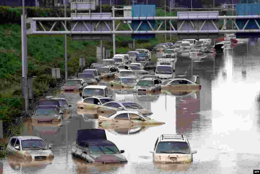 July 28: Vehicles are submerged in floodwater after heavy rain in Seoul, South Korea. Thousands of rescuers used heavy machinery and shovels Thursday to clear mud and search for survivors after huge landslides and flooding killed more than 40 people. (AP 