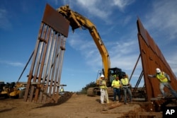 Construction crews install new border wall sections, Jan. 9, 2019, seen from Tijuana, Mexico. U.S. President Donald Trump walked out of his meeting with congressional leaders Wednesday as efforts to end the 19-day partial government shutdown fell into deep disarray.