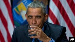 President Barack Obama drinks filtered Flint water during a briefing on the response to the ongoing water crisis by the unified command group at the Food Bank of Eastern Michigan in Flint, Mich., May 4, 2016.