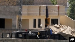 Vehicles parked inside the compound where Osama bin Laden lived in Abbottabad, Pakistan, May 2, 2011