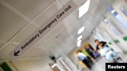 FILE - A patient is pushed down a corridor in Frimley Park Hospital near Camberley, Britain, Jan. 4, 2018. 