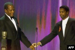 FILE - Actor Sidney Poitier, left, is congratulated by actor Denzel Washington as he accepts the Life Achievement Award at the Sixth Annual Screen Actors Guild Awards in Los Angeles, March 12, 2000.
