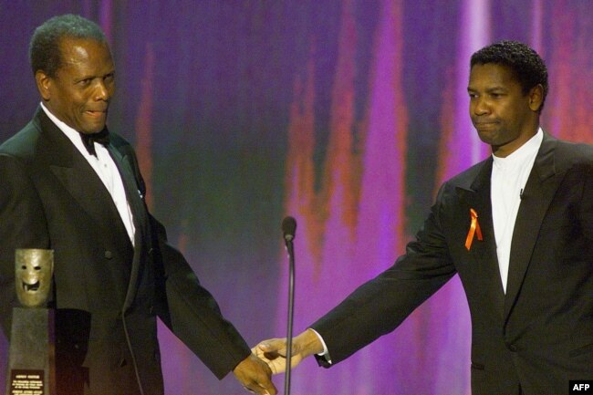 ARCHIVO - El actor Denzel Washington felicita al actor Sidney Poitier, a la izquierda, al aceptar el premio Life Achievement Award en la Sexta edición de los Screen Actors Guild Awards en Los Ángeles, el 12 de marzo de 2000.