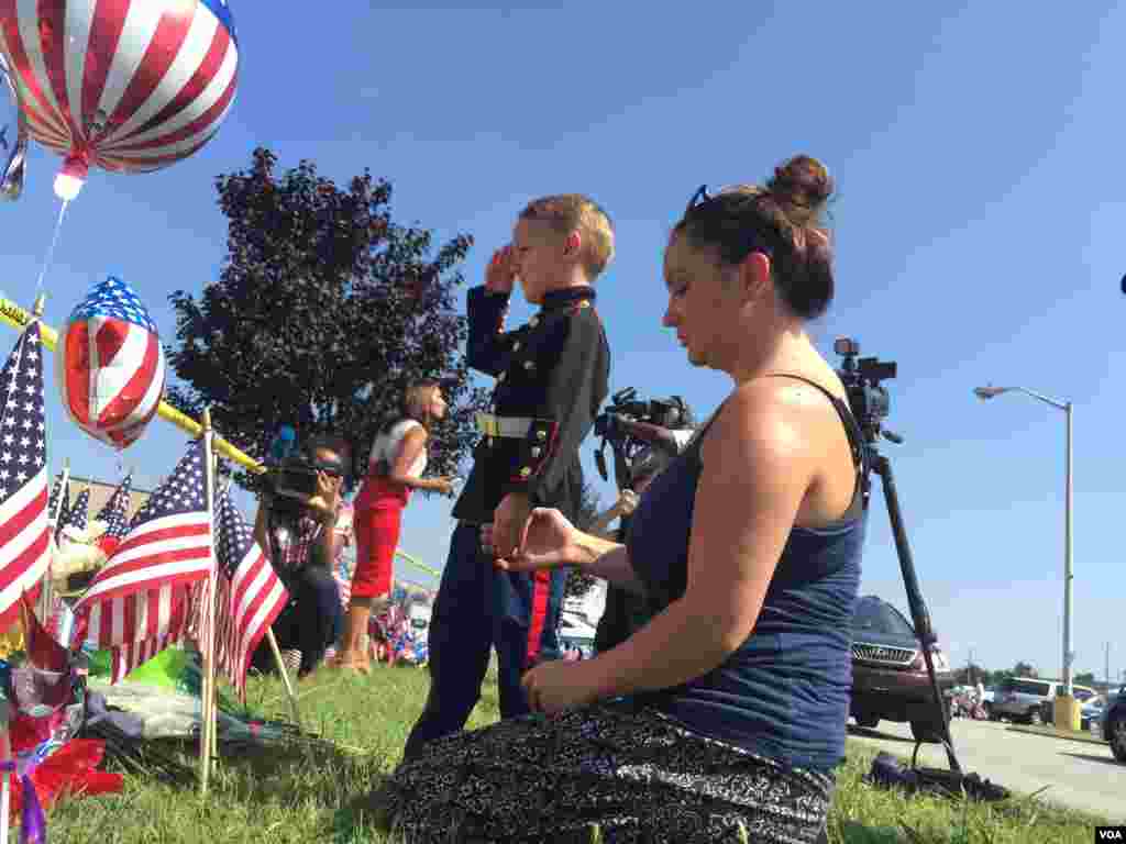 Một cậu bé nghiêm chào tại một nơi tưởng niệm gần hiện trường nơi bốn thủy quân lục chiến Mỹ bị bắn chết ở thành phố Chattanooga, bang Tennessee. (VOA/ S. Behn)