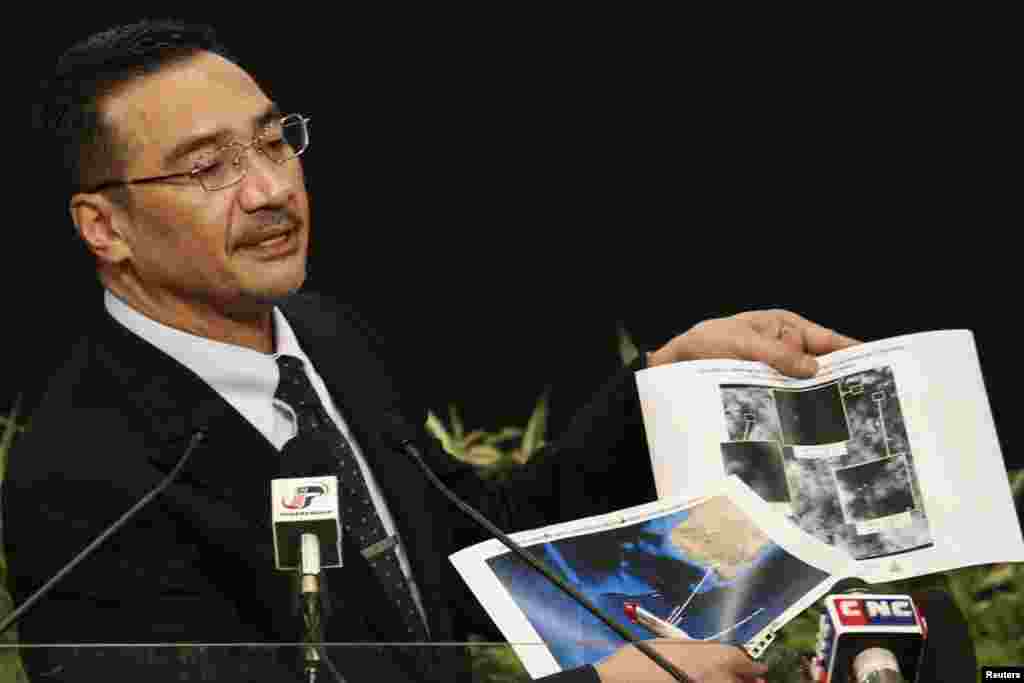 Menteri Transportasi Malaysia Hishammuddin Hussein memegang foto-foto satelit ketika berbicara tentang pencarian pesawat dengan nomor penerbangan MH370, dalam konferensi pers di Putra World Trade Center di Kuala Lumpur, 26 Maret 2014.